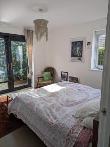 a bedroom with a bed and a large window at Cosy Garden View Room in East Grinstead