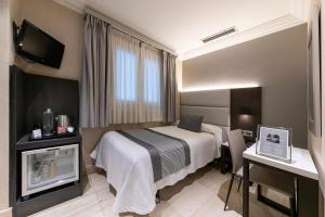 una camera d'albergo con letto e scrivania di Hotel Europa a Pamplona