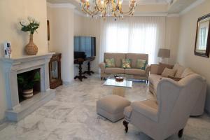 sala de estar con sofá y chimenea en Villa candelaria luxury home, en Bormujos
