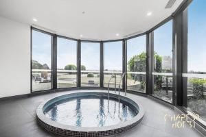 Habitación grande con bañera grande y ventanas. en Chapter 3 Airbnb in Malvern East, en Melbourne