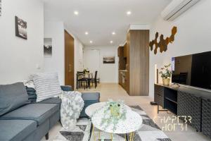 sala de estar con sofá y mesa en Chapter 3 Airbnb in Malvern East, en Melbourne