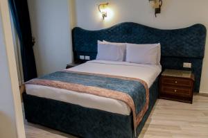 a bedroom with a large bed with a blue headboard at Hor Moheb Hotel in Cairo