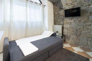 a bed in a room with a stone wall at BERGAMO art in Bergamo