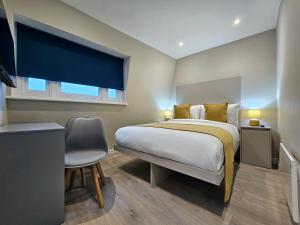 a bedroom with a bed and a desk and a window at BOKA Earls Court in London