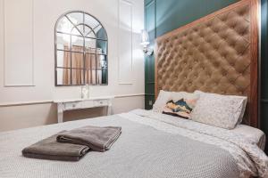 1 dormitorio con 1 cama con cabecero grande y espejo en Klimatyczny apartament w centrum, en Wroclaw