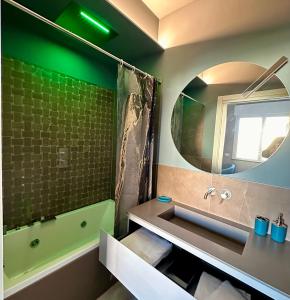 a bathroom with a tub and a sink and a mirror at OliVia Rooms Sauna & Gym in Forlì