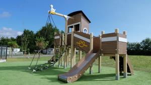 a playground with a slide in a park at Mobil Home XXL 4 chambres - Camping du Vieux Moulin in Vensac