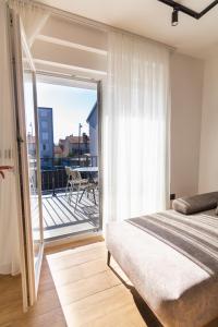 1 dormitorio con cama y vistas a un balcón en CITY LIFE with free parking en Pula