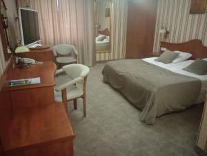 a hotel room with a bed and a desk and chair at Biały Dom Henlex Hotel Restauracja in Poznań