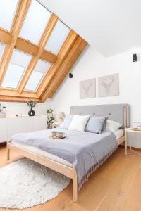 ein Schlafzimmer mit einem großen Bett mit einem Holzrahmen in der Unterkunft Maisonette Apartment in Karlín by Prague Days in Prag