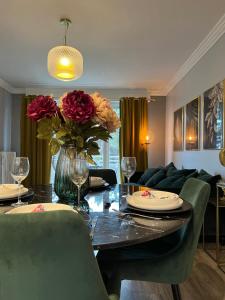 een woonkamer met een tafel met een vaas met bloemen bij T2 Haut Standing, hypercentre terrasse ascenseur in Tourcoing
