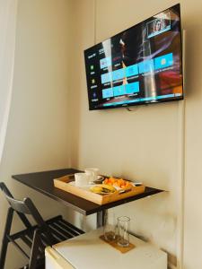 a room with a table with a tv on a wall at Bela Sombra in Vila da Ribeira Brava
