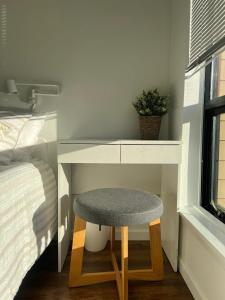 a stool sitting next to a desk next to a bed at Laid Back In Langford in Langford