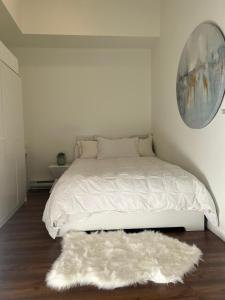 a bedroom with a white bed with a white rug at Laid Back In Langford in Langford