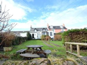 a picnic table in front of a house at Burach in Tobermory
