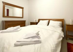 a white bed with white towels on top of it at Bella Vista Red Apartment in Braşov