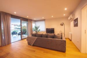 sala de estar con sofá grande y TV en Voula Luxury Apartment, en Atenas