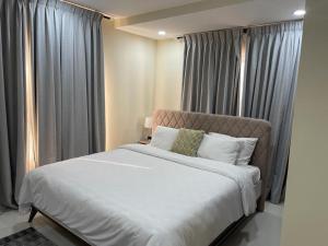 a bedroom with a large bed with gray curtains at Modern 2 bedroom apartment in Sakumono-Tema Beach Rd, Accra-Ghana in Accra