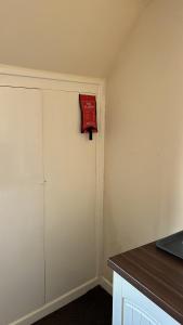 een kamer met een witte deur met een rood bord erop bij The Nook in Bedford