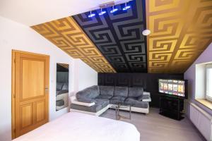 Habitación con sofá y TV en el techo. en A perfect option for people who want to enjoy their stay in Kosice, en Košice