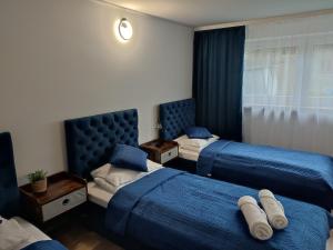 ein Hotelzimmer mit 2 Betten und blauer Bettwäsche in der Unterkunft Apartament LoftyDream in Mielec