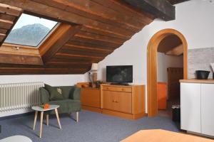 un soggiorno con divano, TV e finestra di Gästehaus Landgraf a Bad Hindelang