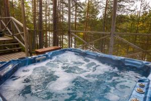 a hot tub with snow on a deck with trees at Villa Ainola in Sapsalampi