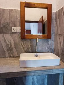- białą umywalkę w łazience z lustrem w obiekcie lake paradise w mieście Habaraduwa Central