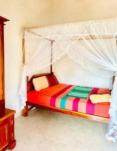 Bett mit Baldachin in einem Zimmer in der Unterkunft lake paradise in Habaraduwa Central