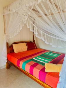 Bett mit Baldachin in einem Zimmer in der Unterkunft lake paradise in Habaraduwa Central