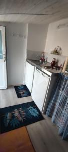 una pequeña cocina con alfombras en el suelo y una encimera en Studio Propre et Cosy, en Le Mesnil-en-Vallée