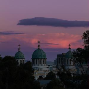 a church with domes with a sunset in the background at Daisy Hotel in Addis Ababa