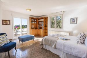 een slaapkamer met een bed, een stoel en een raam bij Casa Alba in Jávea +34 foto's