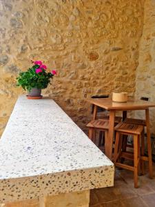 una mesa y dos taburetes y una maceta en maison de village en Saint-Laurent-de-Carnols