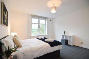 a bedroom with a large bed and a window at Contemporary 3 Bedroom Flat in Fife
