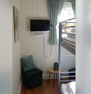 a room with a bunk bed with a television and a chair at Årsunda Strandbad Sjösunda vandrarhem in Årsunda