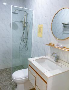 een badkamer met een douche, een toilet en een wastafel bij V-Relaxing Resort (Kompot) កំពត in Kampot