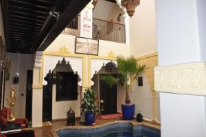 a lobby with a palm tree in a building at Riad des Etoiles in Marrakech