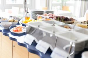 un buffet de comida en una mesa con platos de comida en Hotel Ambiente en Münster