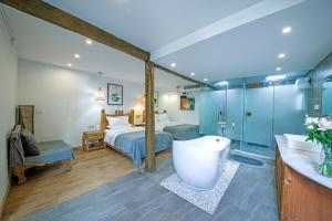 Habitación con baño con cama y bañera. en Lijiang View Holiday Inn en Lijiang
