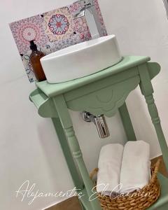 zieloną toaletkę z umywalką i koszem w obiekcie Alojamientos El Carmen w mieście Écija