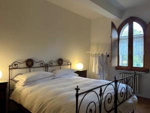 a bedroom with a large bed and a window at Le dimore de Il borgo del balsamico in Albinea