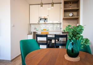 a dining room table with a green vase on it at Sunny Nest Apartment in Fontana