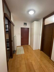 um quarto vazio com uma porta e um piso de madeira em Apartment Krstanovic em Banja Luka