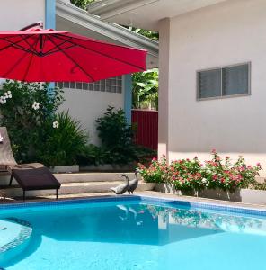 a red umbrella sitting next to a swimming pool at Shrivasta Cottages in Abu