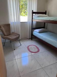 a room with two bunk beds and a chair at Casa praia em Penha - disponível in Penha