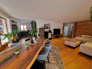 uma sala de estar com uma longa mesa e cadeiras de madeira em Exclusive 120 qm Wohnung am Wössner em Unterwössen