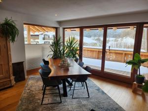 uma sala de estar com uma mesa de madeira e cadeiras em Exclusive 120 qm Wohnung am Wössner em Unterwössen
