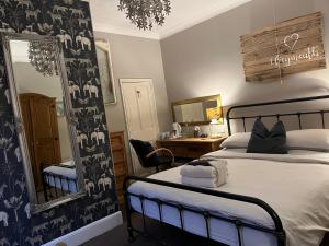 a bedroom with a bed and a mirror and a desk at Kelston Guest House in Weymouth
