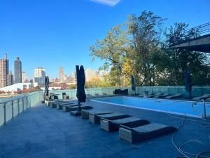 a swimming pool with umbrellas on top of a building at Lore&ken shared apartment in Long Island City